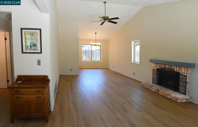 a view of an empty room with a window and a fireplace