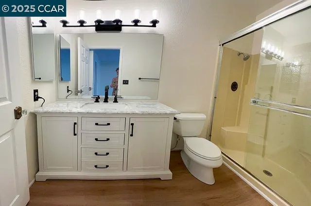 a bathroom with a sink a toilet and shower
