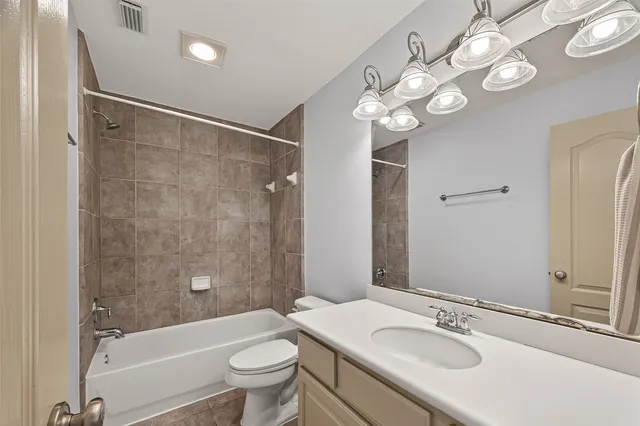 a bathroom with a sink a toilet a mirror a bathtub and shower