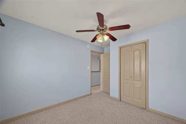an empty room with a fan and a fan
