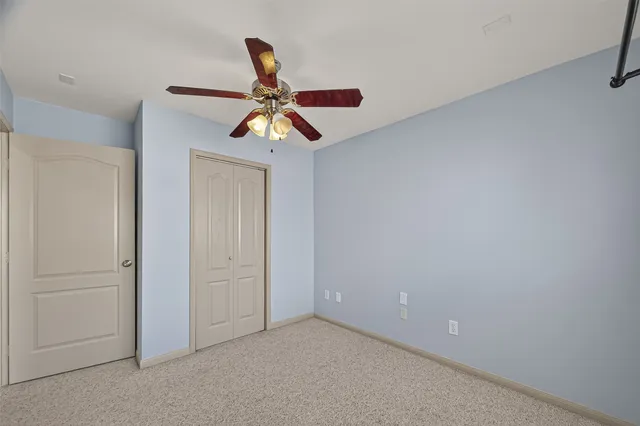 an empty room with a ceiling fan and a window
