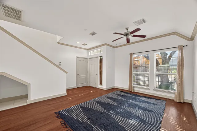a view of a livingroom with wooden floor and a ceiling fan