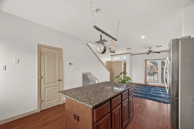 a kitchen with stainless steel appliances granite countertop a refrigerator a stove and a wooden floors