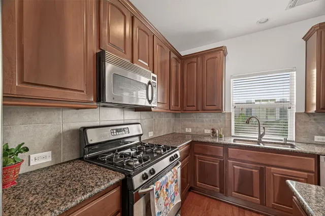a kitchen with granite countertop cabinets stainless steel appliances and a sink