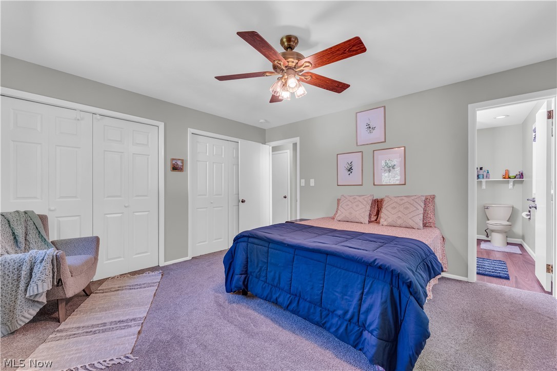 6821 Thornapple Road Gates Mills, OH 44040 - Photo 19 of 42 Carpeted room featuring a ceiling fan with light fixture, multiple closet doors, and an adjacent bathroom with wood-finish flooring and a toilet