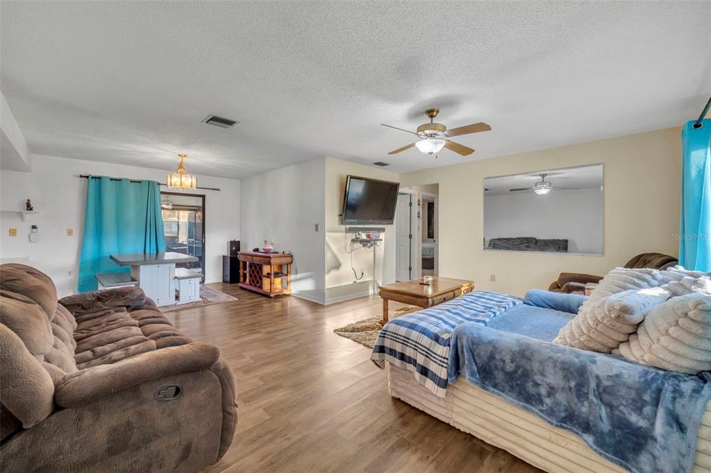 202 Bryan Street Eustis, FL 32726 - Photo 4 of 53 a living room with furniture a fireplace and a flat screen tv