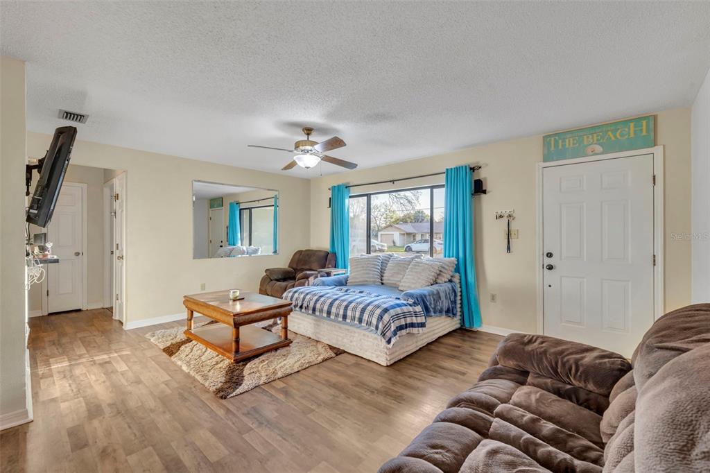 202 Bryan Street Eustis, FL 32726 - Photo 6 of 53 a spacious bedroom with a bed and a chandelier