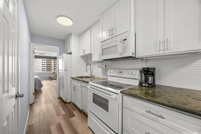 a kitchen with granite countertop a stove sink and cabinets