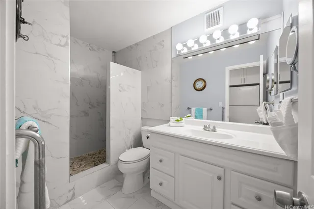 a spacious bathroom with a granite countertop sink a toilet and a mirror