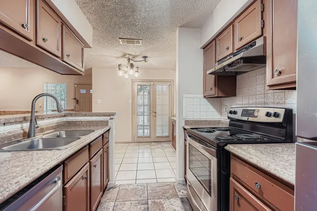 a kitchen with stainless steel appliances granite countertop a sink stove and cabinets
