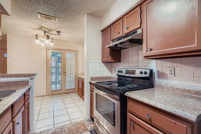 a kitchen with stainless steel appliances granite countertop a stove a sink and a microwave