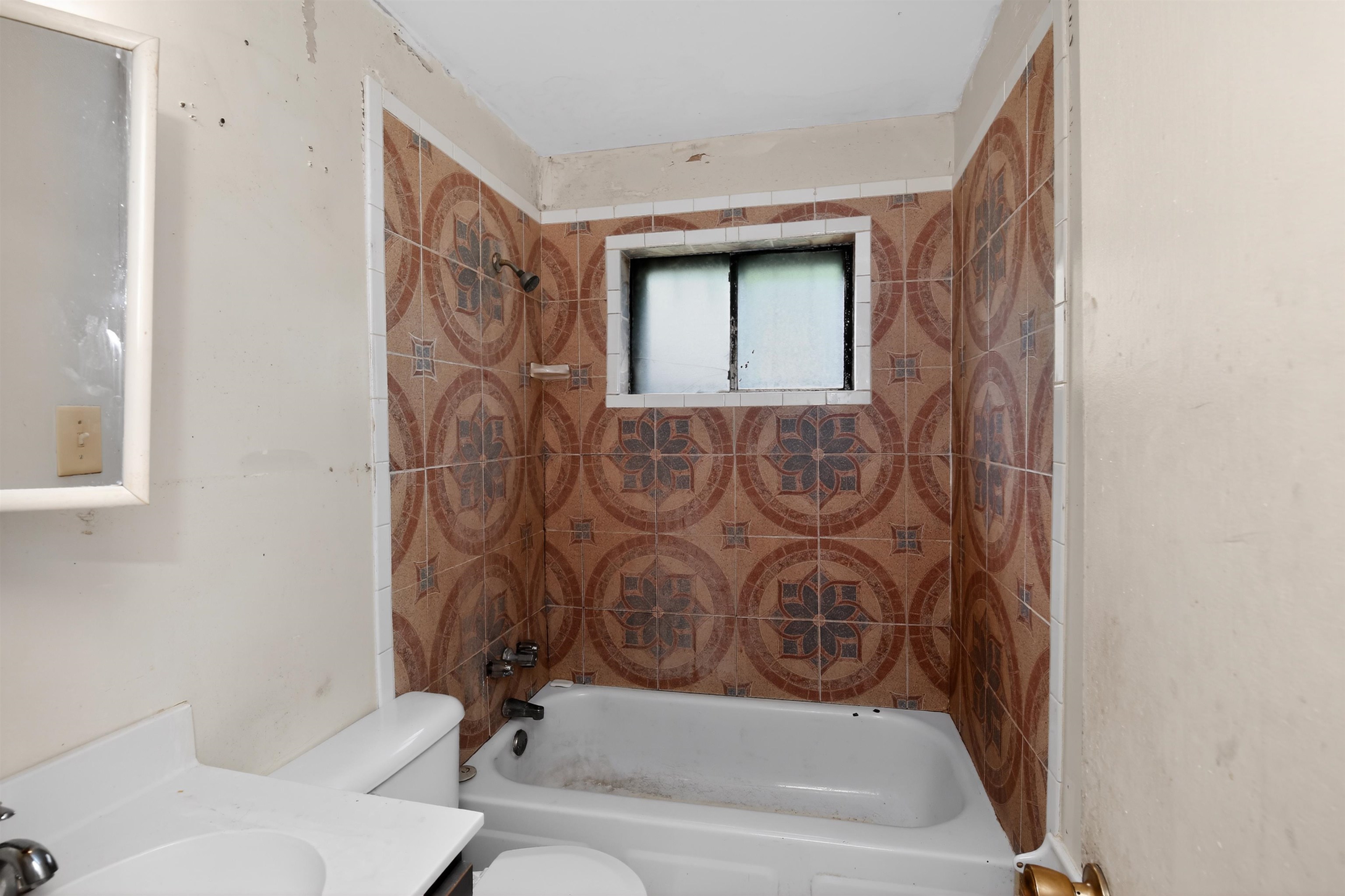 3451 Birdsong Ferry Road Memphis, TN 38118 - Photo 25 of 27 Bathroom featuring a white porcelain tub, patterned wall tile surround, and a vanity with a white countertop