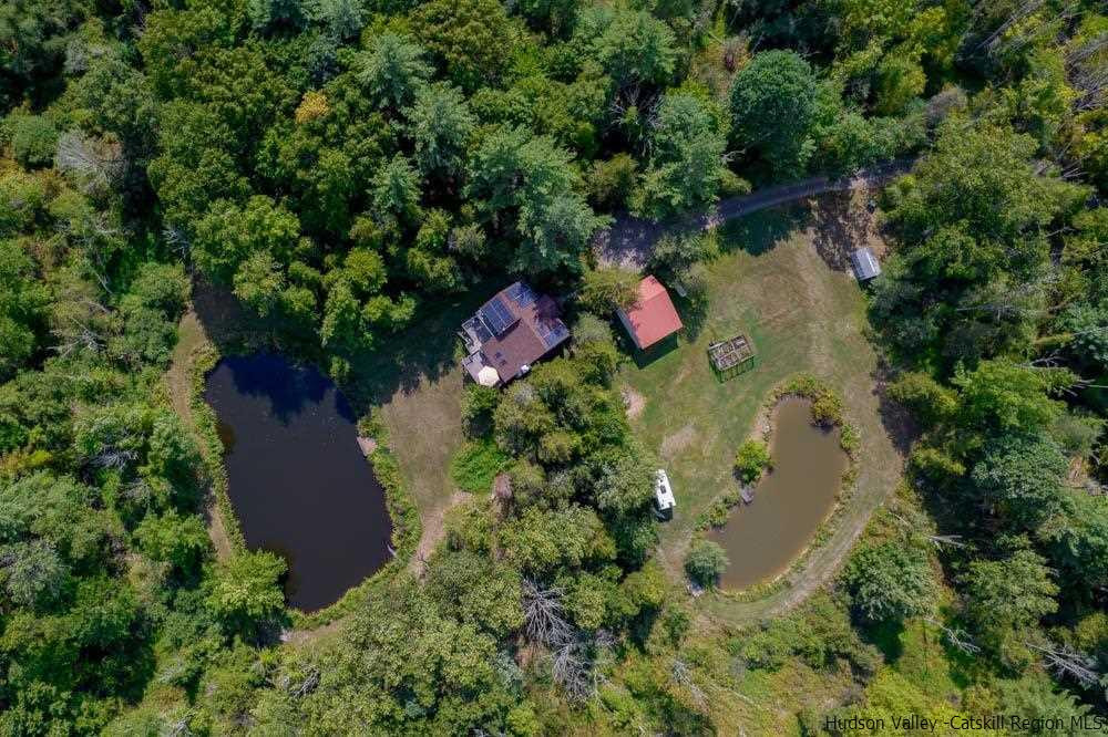 an aerial view of a house with a yard and lake view