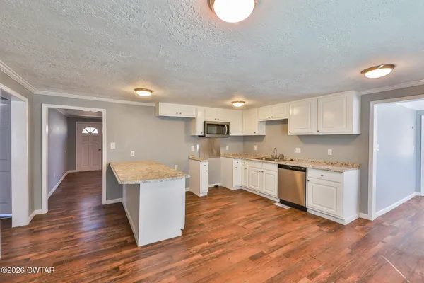 a kitchen with a refrigerator and white cabinets