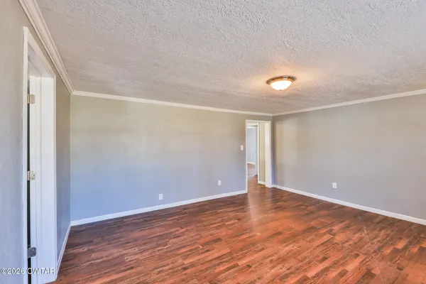 a view of an empty room with wooden floor