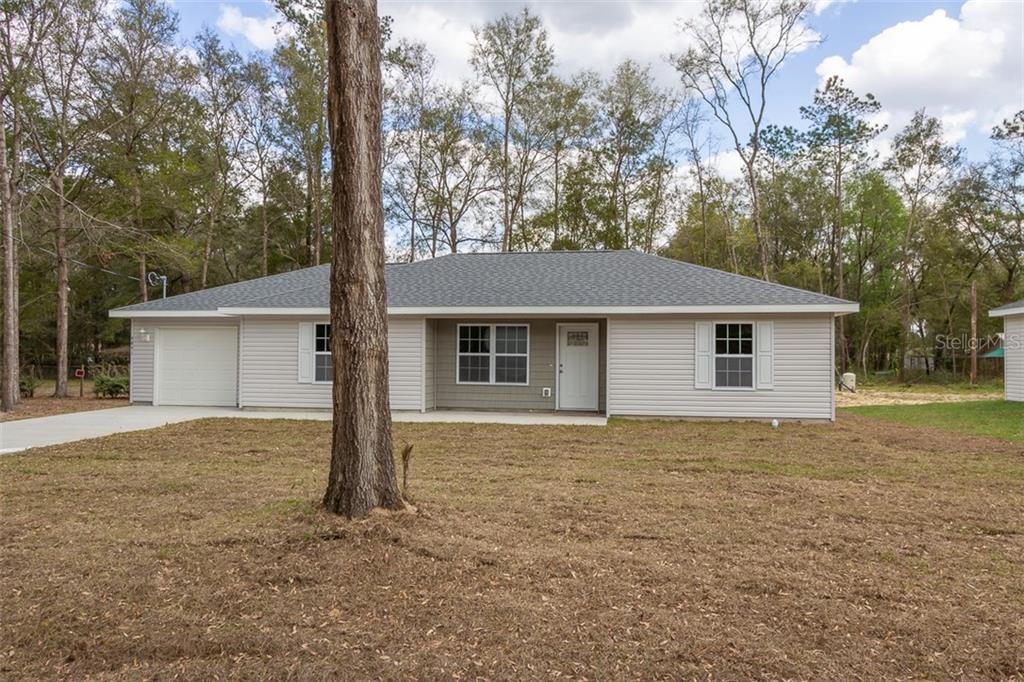 7025 Hemlock Road Ocala, FL 34472 - Photo 1 of 1 a view of a house with a yard and large tree