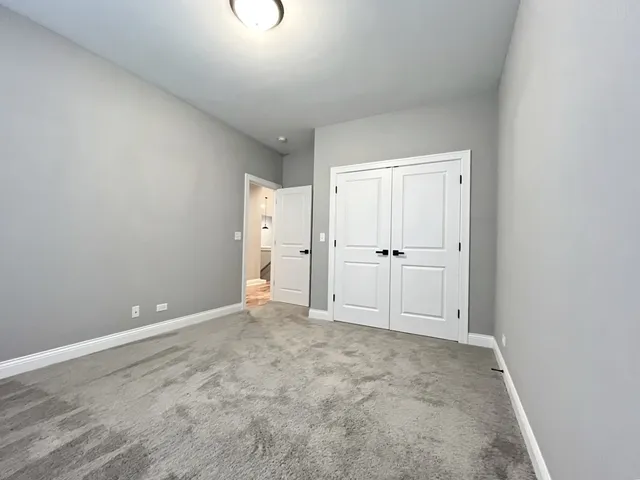 an empty room with white wall and mirror