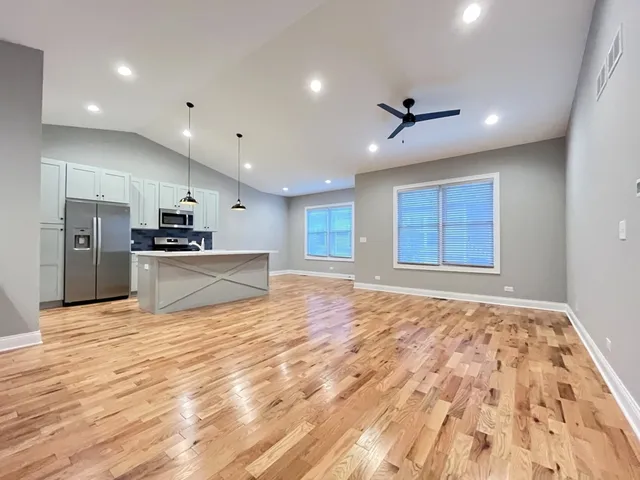 a view of an empty room with kitchen appliances and a window