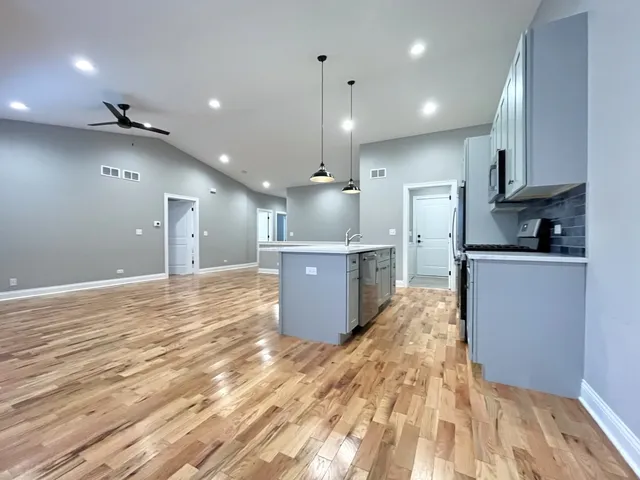a kitchen with kitchen island a sink stainless steel appliances and cabinets