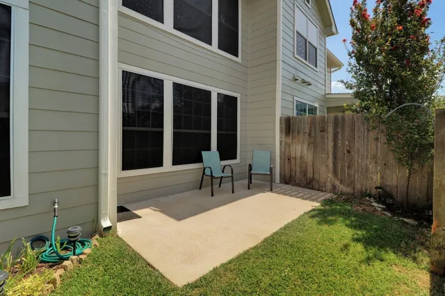a view of a chair and table in backyard of the house