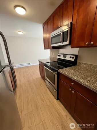 a kitchen with granite countertop wooden cabinets and stainless steel appliances