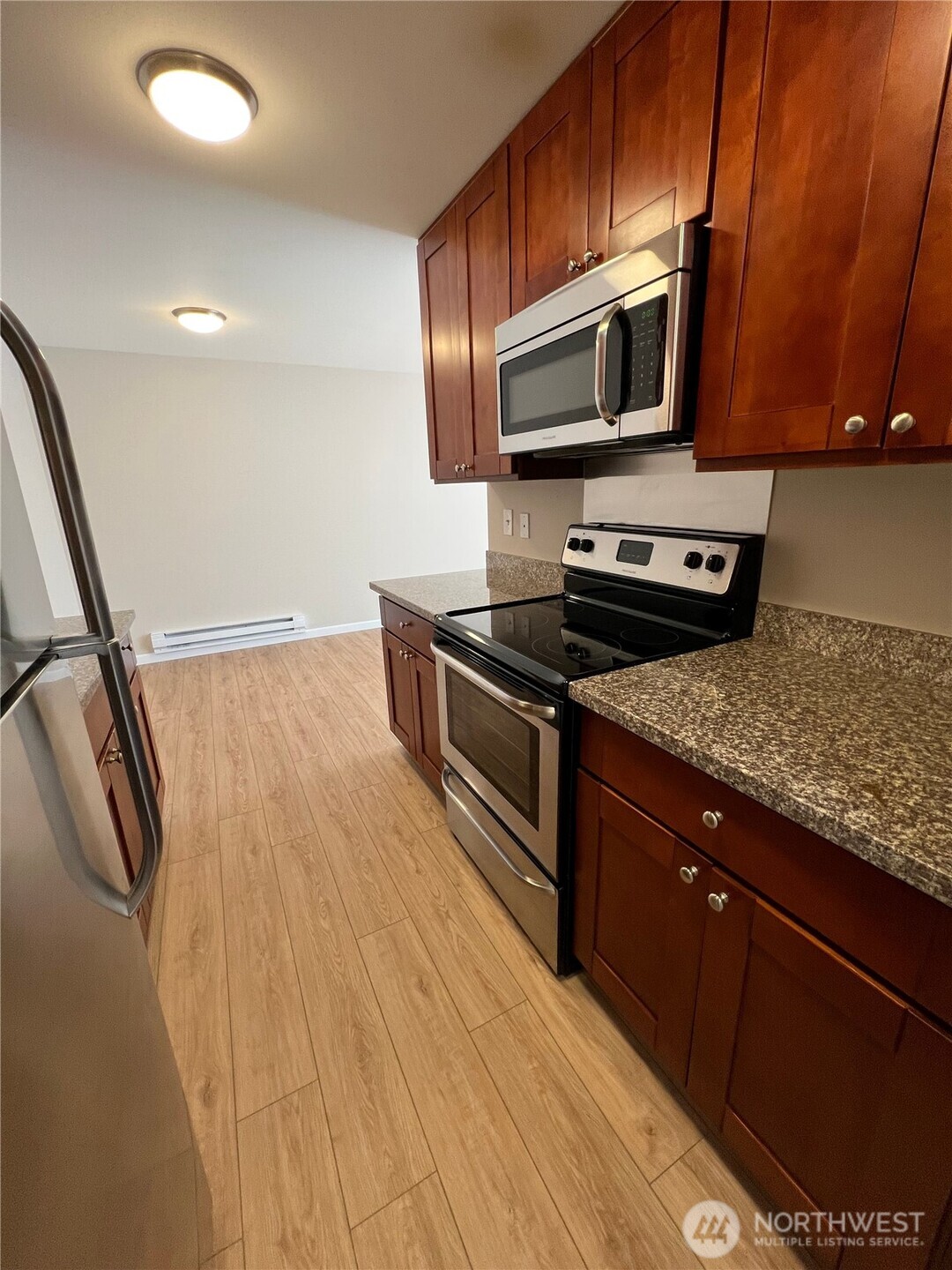 3326 Lombard Avenue, Unit 3 Everett, WA 98201 - Photo 3 of 10 a kitchen with granite countertop wooden cabinets and stainless steel appliances