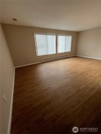 wooden floor in an empty room with a window