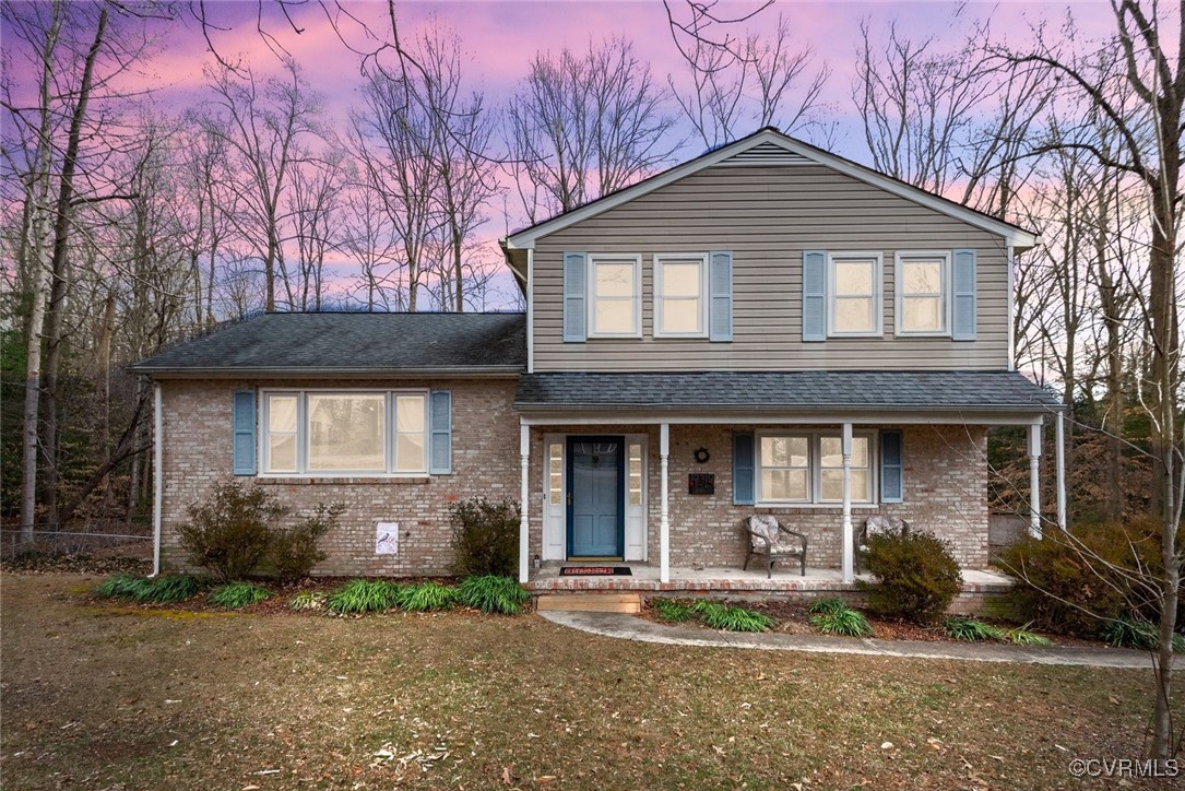 View of front of property with a lawn and covered