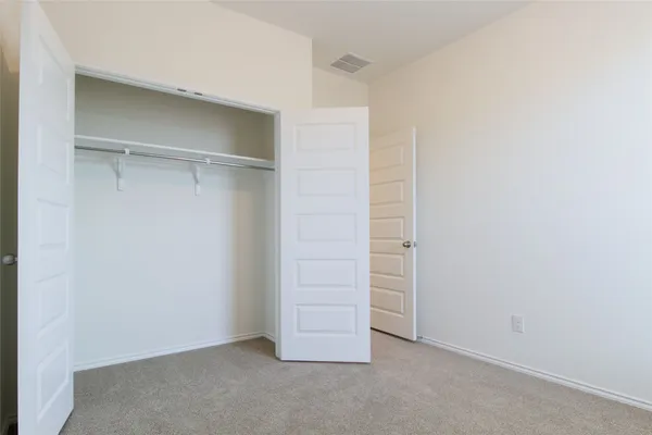 a view of walk in closet with empty racks