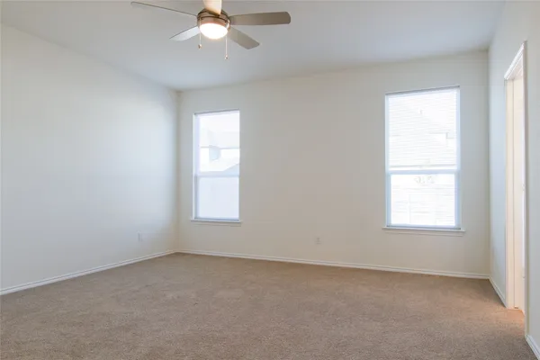 an empty room with a window and a fan