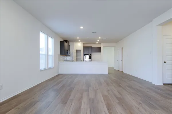 a view of a kitchen with wooden floor and a window