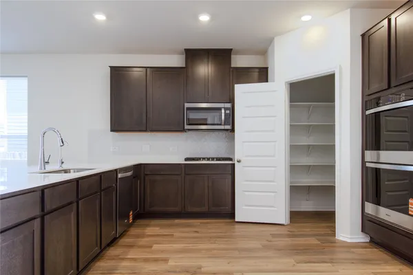 a large kitchen with wooden floors and wooden cabinets