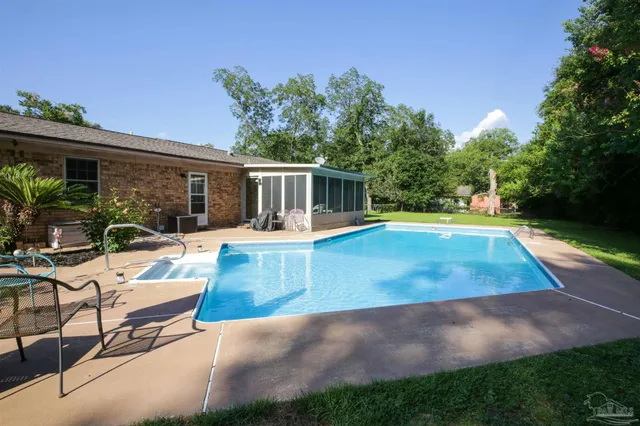 a view of a house with swimming pool and sitting area