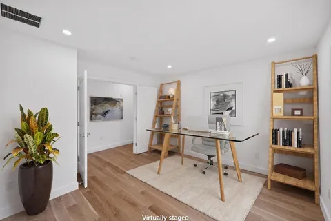 a view of an empty room with wooden floor