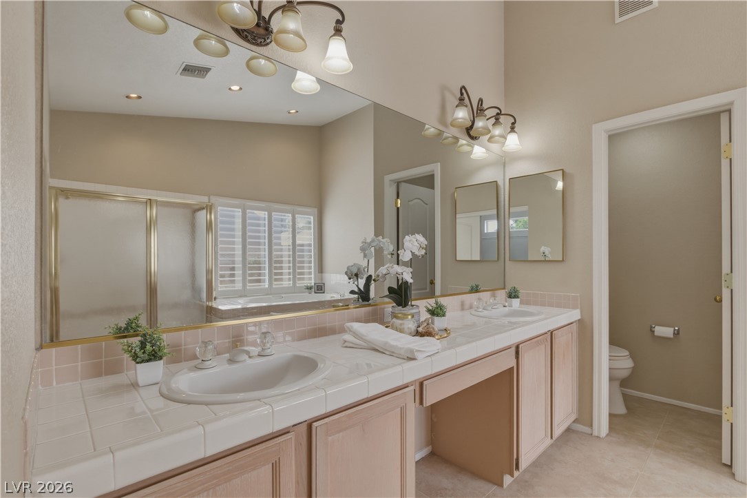 29 Olive Tree Henderson, NV 89074 - Photo 35 of 60 This spacious bathroom offers dual vanities, a large mirror, and ample natural light.