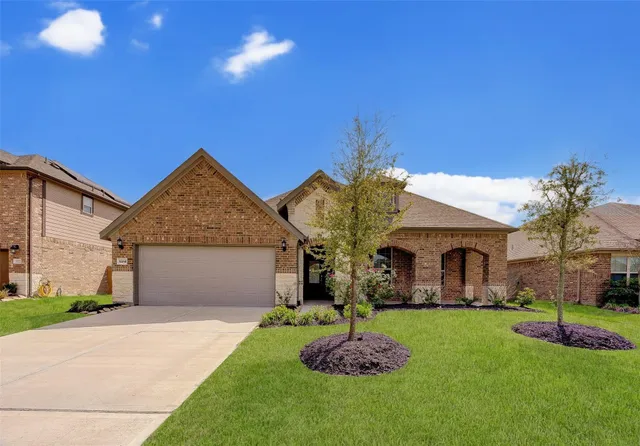 a front view of a house with a garden and plants