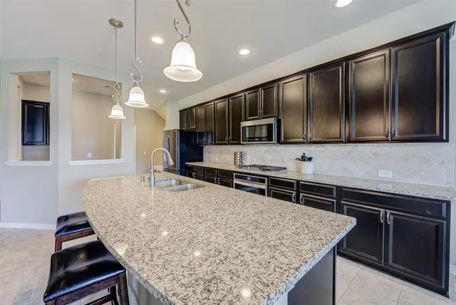 a kitchen with stainless steel appliances granite countertop a sink stove and microwave
