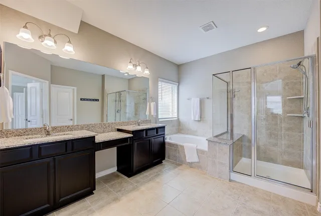 a bathroom with a granite countertop sink mirror and a bathtub