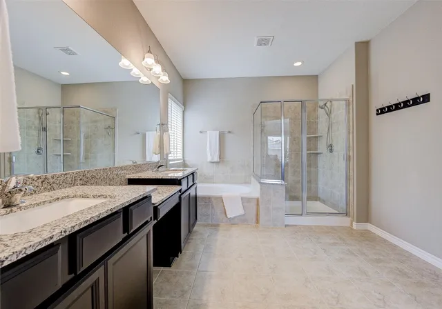 a bathroom with a granite countertop sink a toilet a mirror and shower