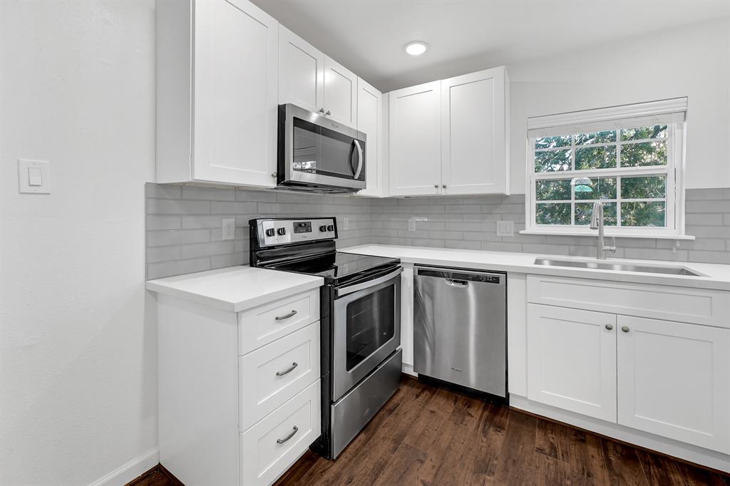 a kitchen with white cabinets stainless steel appliances and sink