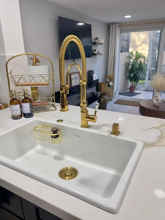 a kitchen with a sink white cabinets and black appliances