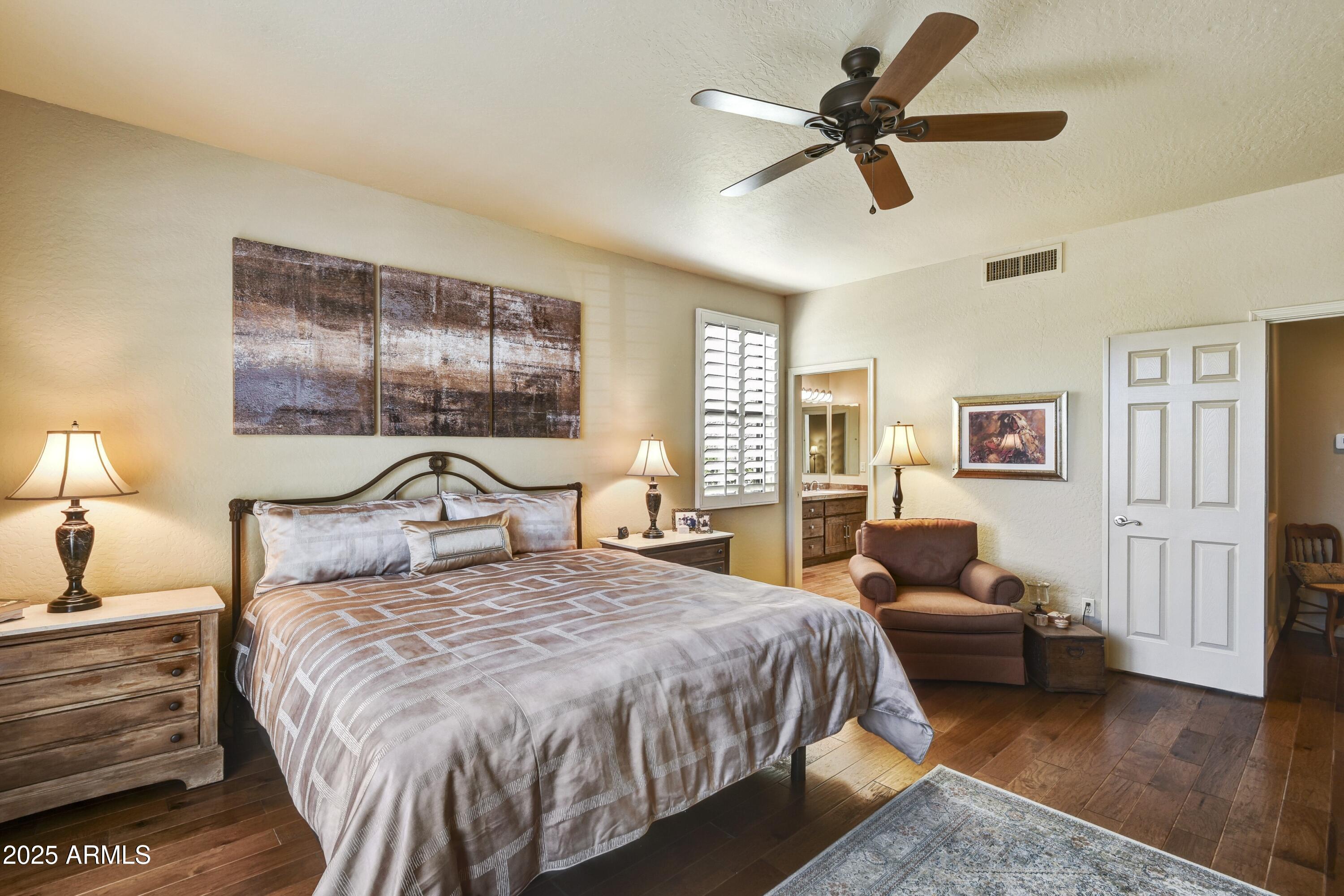 25004 North Vado Court Rio Verde, AZ 85263 - Photo 11 of 18 a bedroom with a bed and dresser with wooden floor