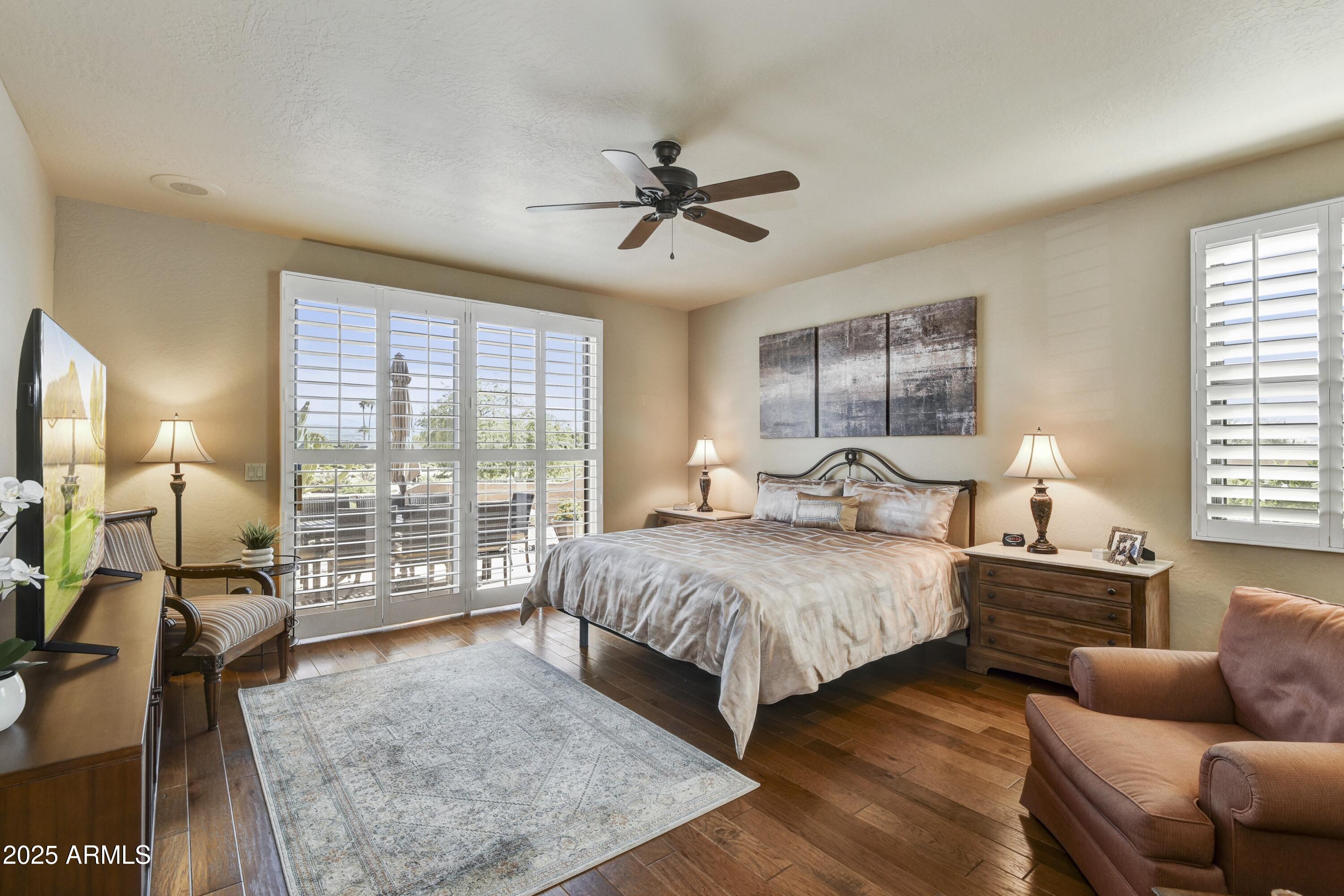 25004 North Vado Court Rio Verde, AZ 85263 - Photo 10 of 18 a spacious bedroom with a balcony a bed and glass walk in closet