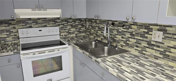 a kitchen with granite countertop white cabinets and white appliances