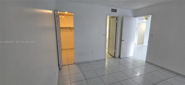 a view of a hallway with closet and a window
