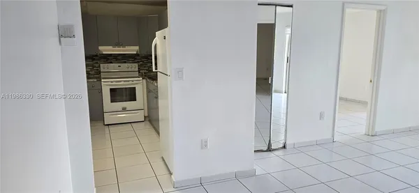a kitchen with white cabinets and white appliances