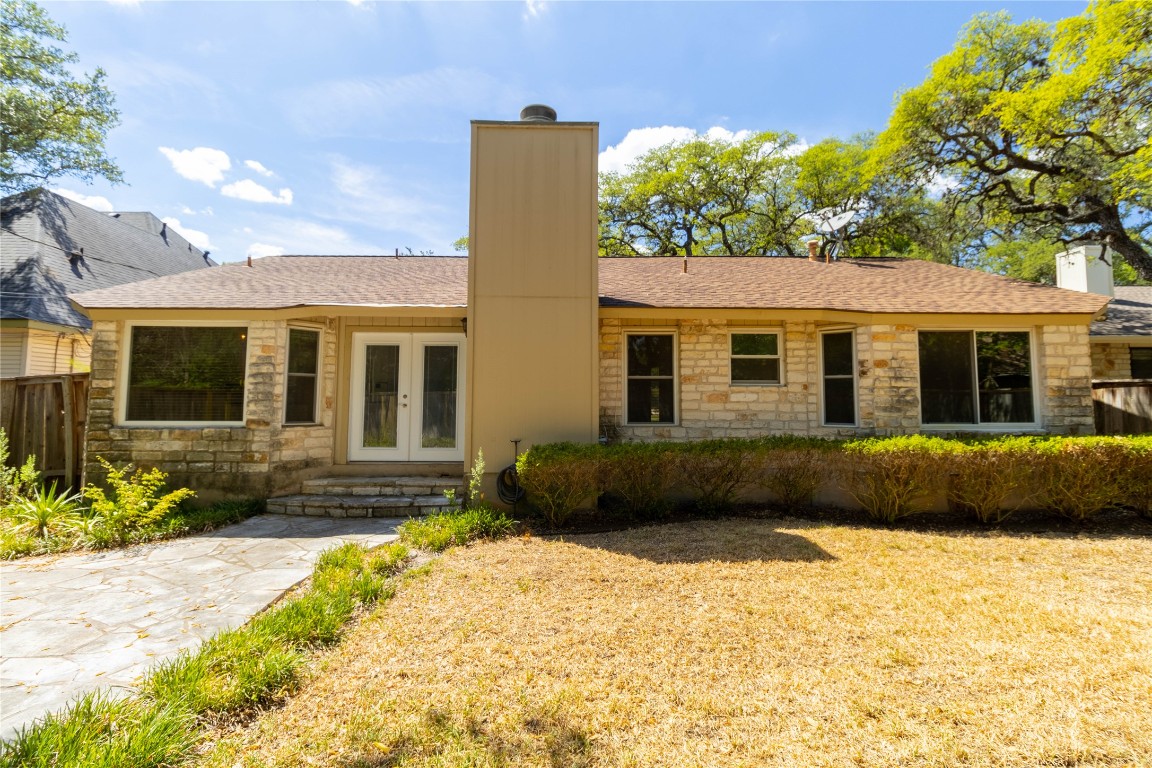 5839 Secrest Drive Austin, TX 78759 - Photo 29 of 34 Back of property featuring a chimney, french doors, stone siding, and a shingled roof