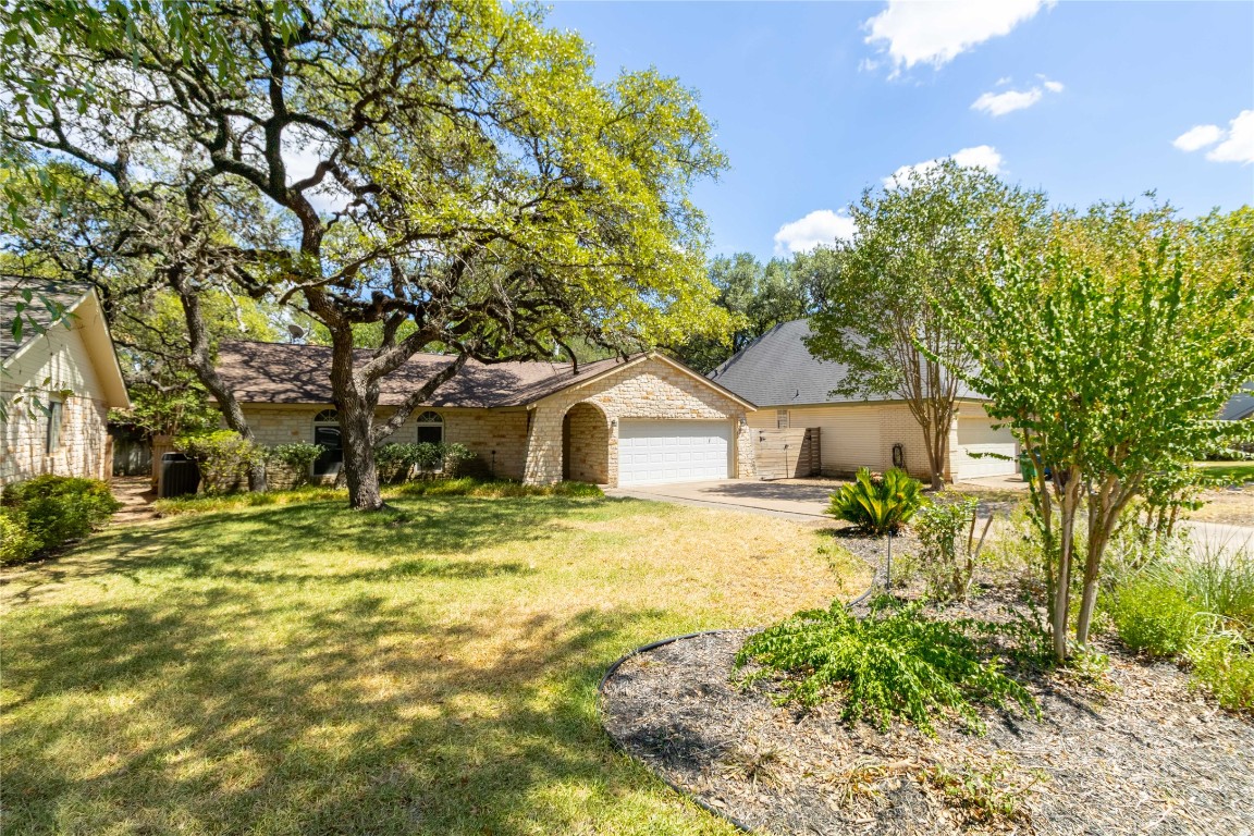 5839 Secrest Drive Austin, TX 78759 - Photo 4 of 34 View of front of home featuring an attached garage, driveway, a front lawn, and brick siding
