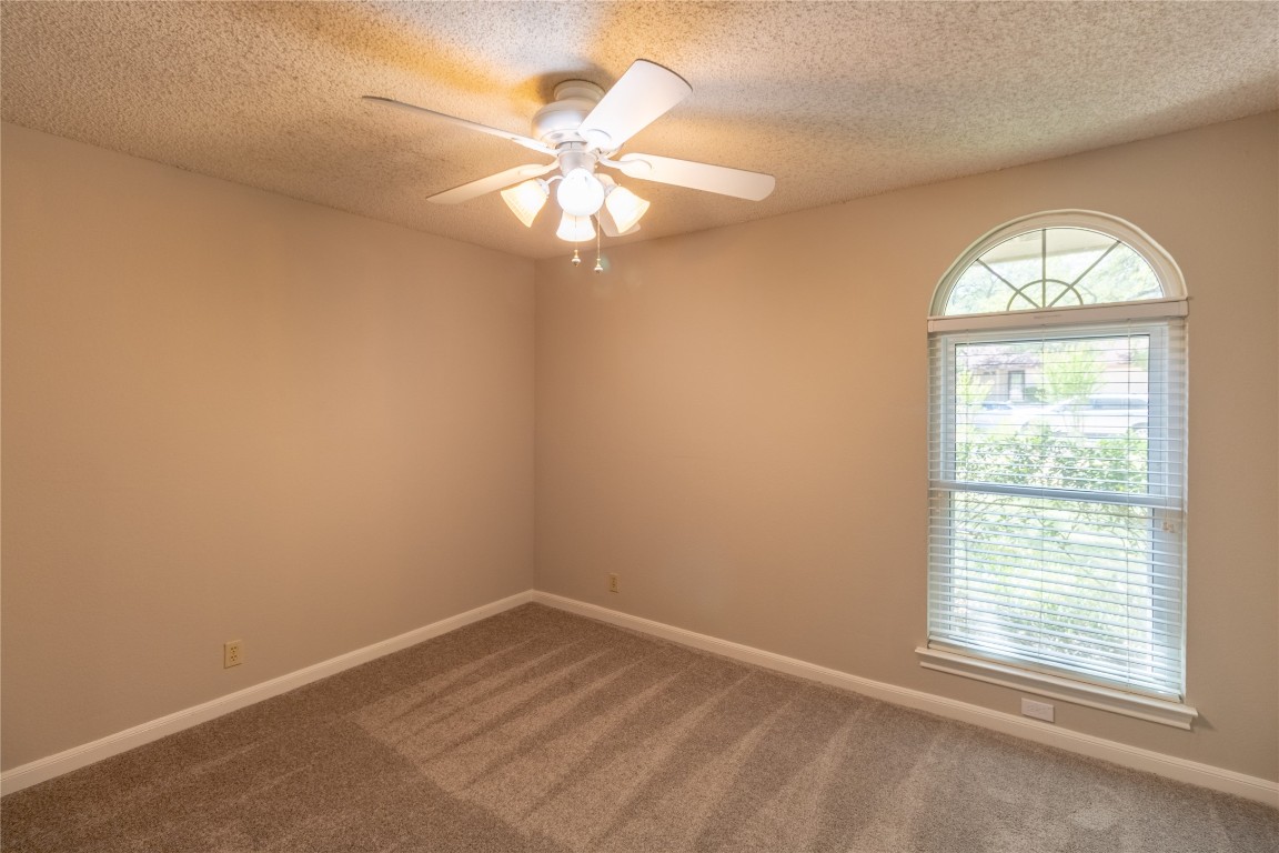 5839 Secrest Drive Austin, TX 78759 - Photo 7 of 34 Carpeted spare room featuring a textured ceiling and a ceiling fan
