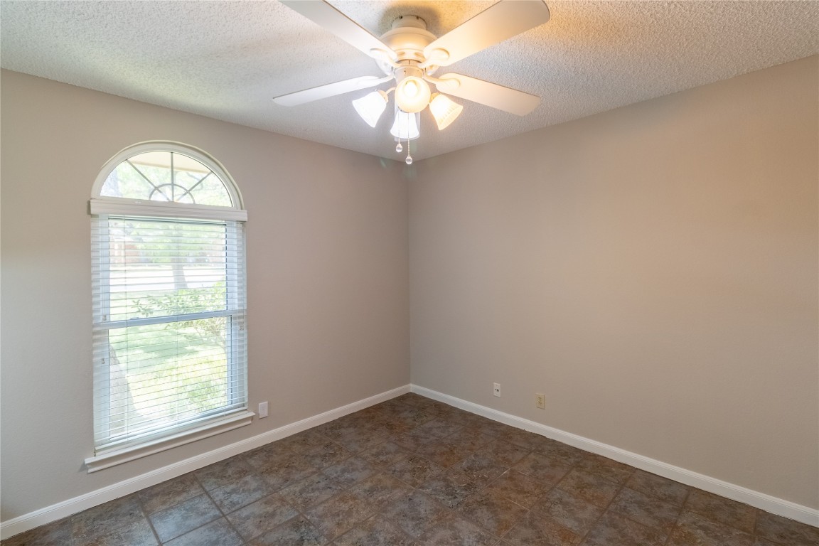 5839 Secrest Drive Austin, TX 78759 - Photo 10 of 34 Empty room with a textured ceiling and ceiling fan